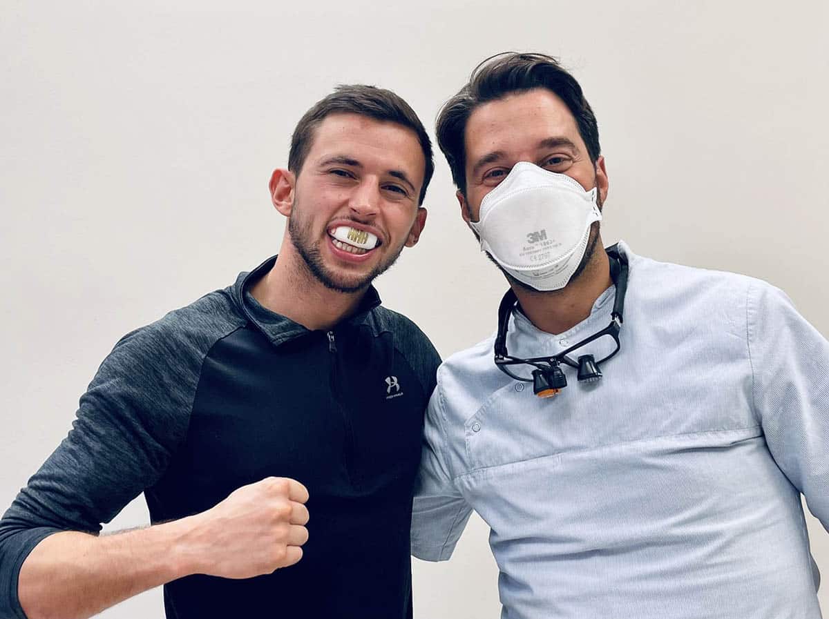 A dentist wearning safety mask with sports person self fit white mouth guard posing