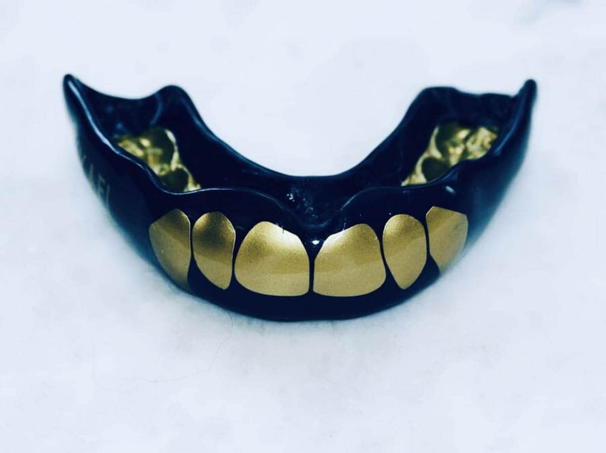 Self fit black mouth guard with golden visible teeth signs