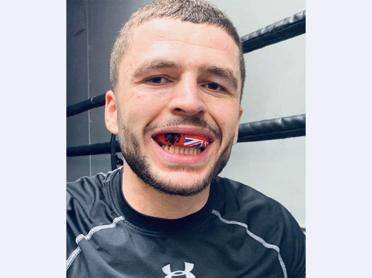 A sport person with Red Boxing teeth gaurd clip in mouth.