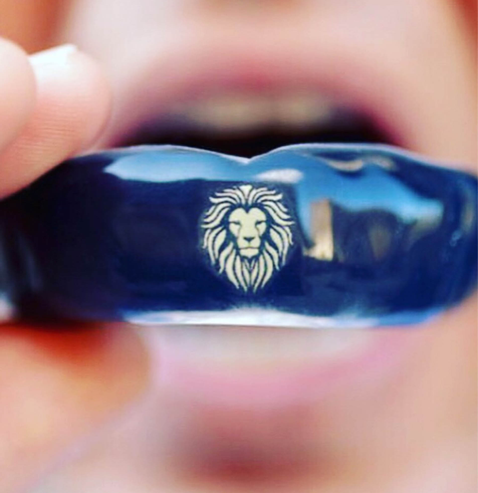 A man wearning blue mouth guard with lion sign on the middle.