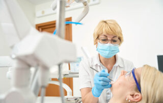 Woman dentist wearing a protective mask treats her teeth